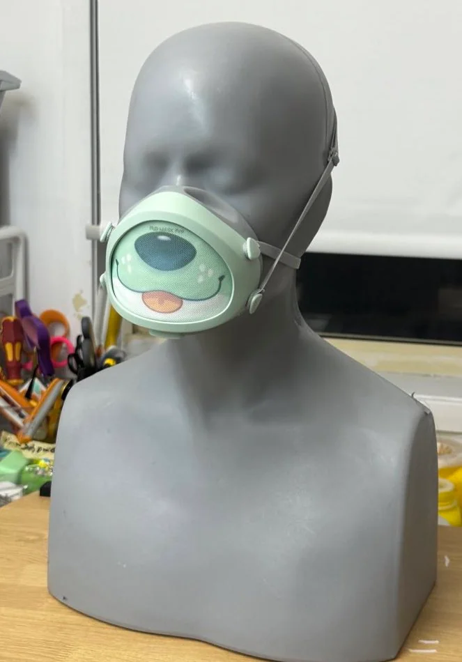 A grey mannequin wears a Flo Mask, a mesh has been inserted into the front with a cute canine snout painted on it